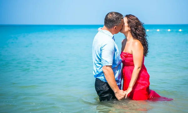 Glückliches Liebespaar an einem tropischen Strand vor der meeresähnlichen Insel — Stockfoto