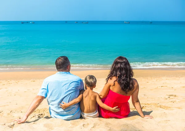 Happy young family resting on the beach on the ocean sea — Stock Photo, Image