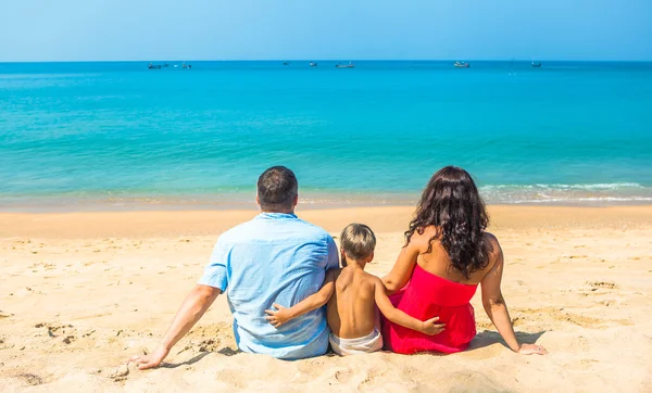 Happy young family resting on the beach on the ocean sea — Stock Photo, Image