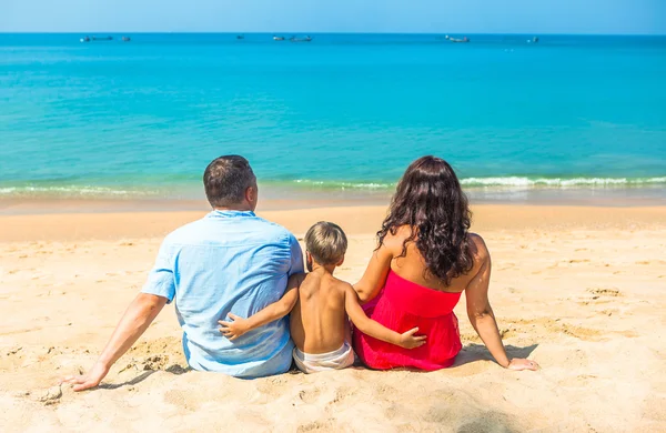 Happy young family resting on the beach on the ocean sea — Stock Photo, Image