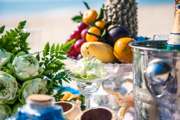 Mesa de bodas con fruta y champán en la playa — Foto de Stock