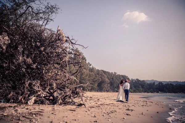 Joven pareja hermosa en la ceremonia del arco de boda en la playa con vistas al mar — Foto de Stock