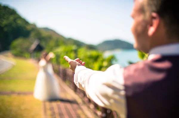 Händer i form av ett hjärta på bakgrund av havet — Stockfoto