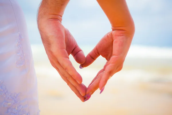 Hands in the shape of a heart on the background of the sea — Stock Photo, Image