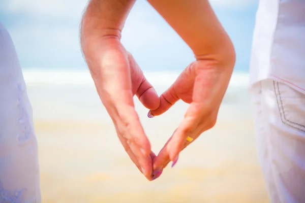 Hands in the shape of a heart on the background of the sea — Stock Photo, Image