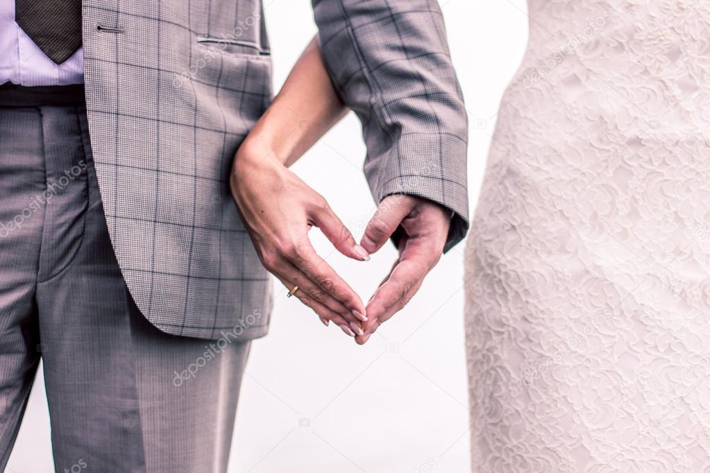 Hands in the shape of a heart on the background of the sea