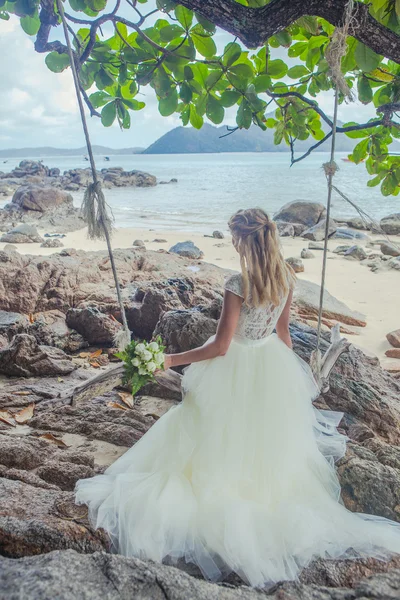 Piękna dziewczyna szczęśliwy w sukni ślubnej w tło wesele łuków nad brzegiem morza — Zdjęcie stockowe