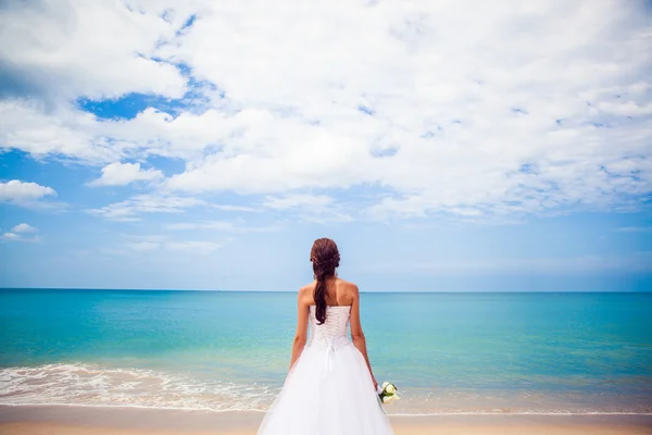 Noiva Menina feliz em um vestido de noiva pelo mar praia fundo oceano — Fotografia de Stock