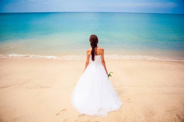 Šťastná dívka nevěsta ve svatebních šatech sea beach pozadí oceánem — Stock fotografie