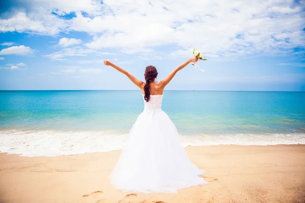 เจ้าสาวสาวสาวมีความสุขในชุดแต่งงานริมชายหาดพื้นหลังมหาสมุทร — ภาพถ่ายสต็อก