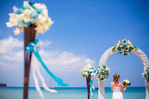 Menina feliz bonita no vestido de noiva no fundo dos arcos de casamento à beira-mar — Fotografia de Stock