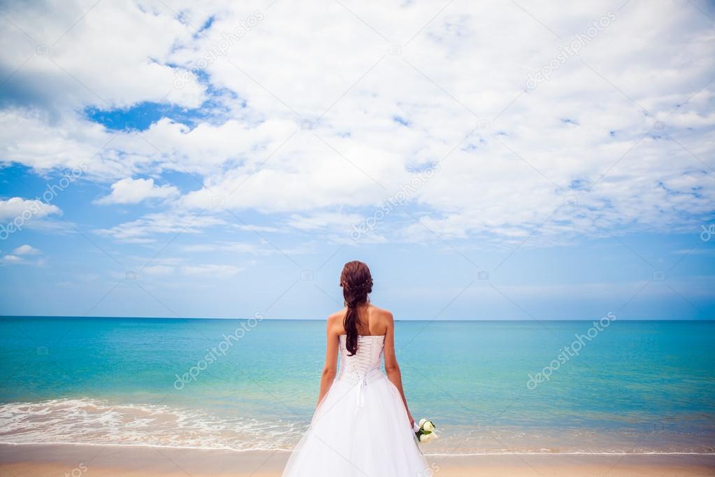 Bride Happy girl in a wedding dress by the sea beach background ocean