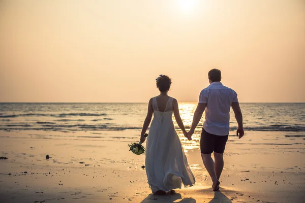 Pareja cariñosa en una playa tropical contra el fondo del mar puesta de sol del océano — Foto de Stock