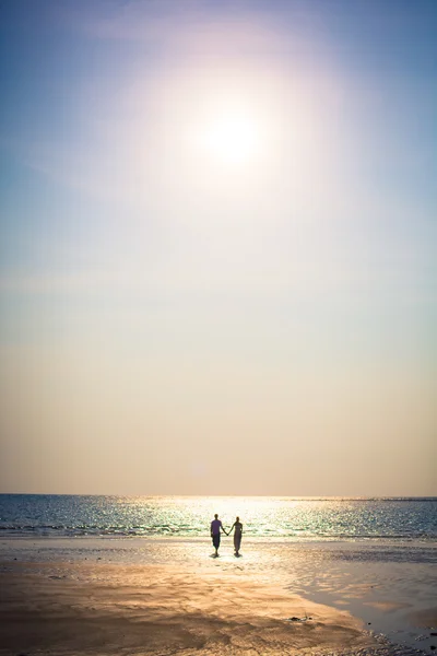 Liebespaar an einem tropischen Strand vor dem Hintergrund des Meeres Sonnenuntergang Stockfoto