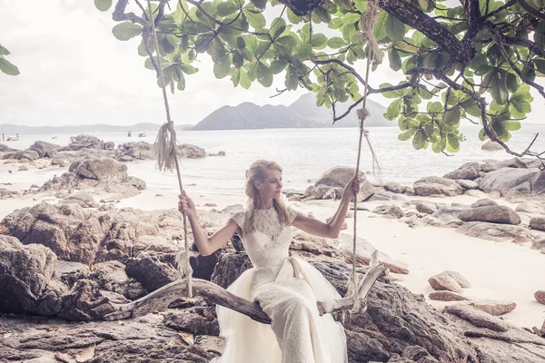 Красивая девушка в свадебном платье на качелях на фоне Андаманского моря — стоковое фото