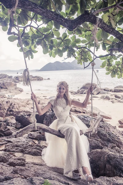 Schöne Mädchen in einem Hochzeitskleid auf der Schaukel im Hintergrund der andaman sea similan island — Stockfoto