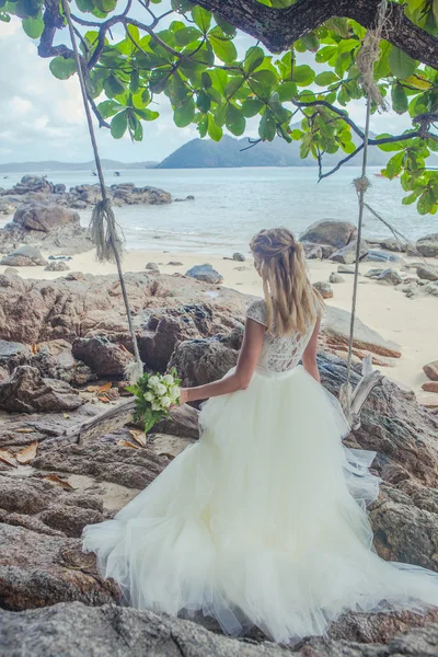 Schöne Mädchen in einem Hochzeitskleid auf der Schaukel im Hintergrund der andaman sea similan island — Stockfoto