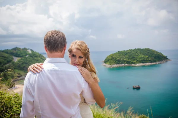 Glückliches Liebespaar an einem tropischen Strand gegenüber dem Meer ähnlicher Inselaussichtspunkt — Stockfoto