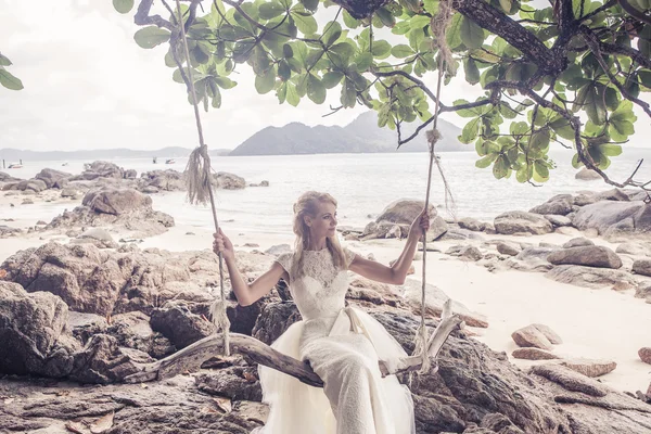 Schöne Mädchen in einem Hochzeitskleid auf der Schaukel im Hintergrund der andaman sea similan island Stockbild