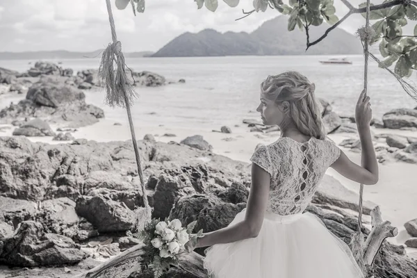 Schöne Mädchen in einem Hochzeitskleid auf der Schaukel im Hintergrund der andaman sea similan island lizenzfreie Stockfotos