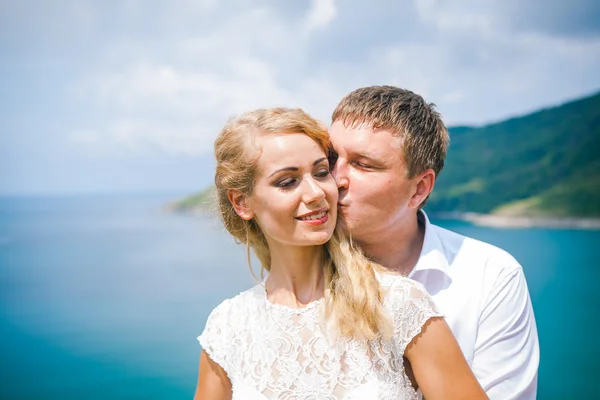 Glückliches Liebespaar an einem tropischen Strand gegenüber dem Meer ähnlicher Inselaussichtspunkt Stockbild