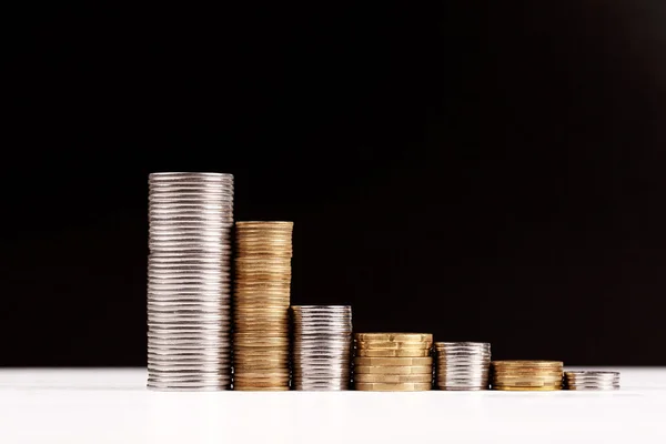 Montones de monedas sobre fondo negro — Foto de Stock