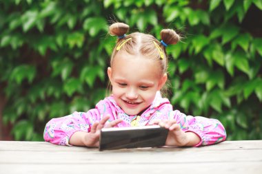 bir akıllı telefon kullanan yürümeye başlayan çocuk kız