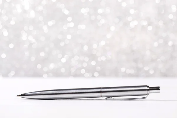 Metalowy długopis na tle sparkle — Zdjęcie stockowe