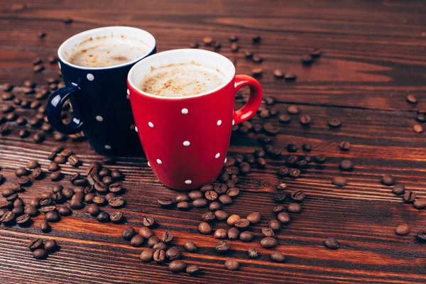 Deux tasses de café avec des grains de café — Photo