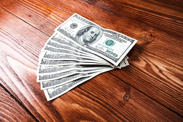 Dollars op houten tafel — Stockfoto