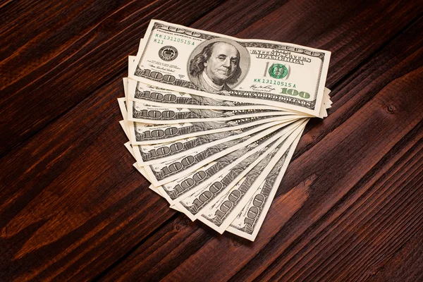 Dollars op houten tafel — Stockfoto