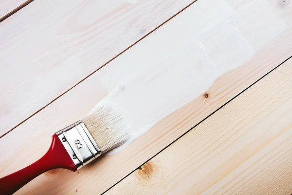 Paint brush painting on wooden surface — Stock Photo, Image