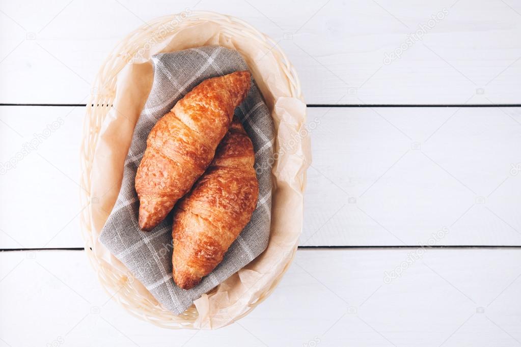 croissants in a basket on wooden table