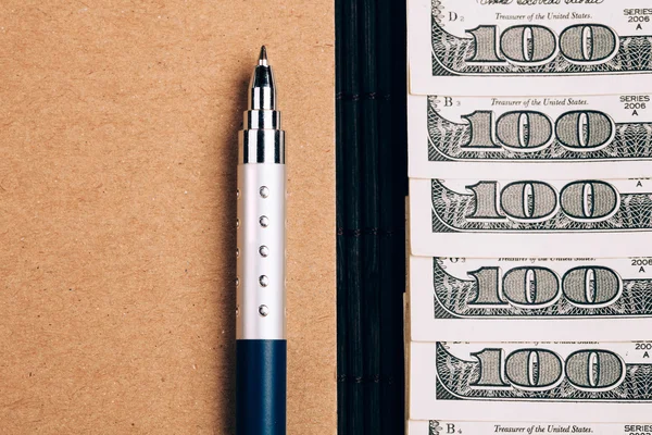 Записная книжка, ручка и доллары , — стоковое фото