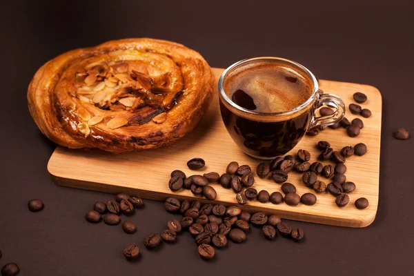 Tasse Kaffee mit leckerem Brötchen — Stockfoto