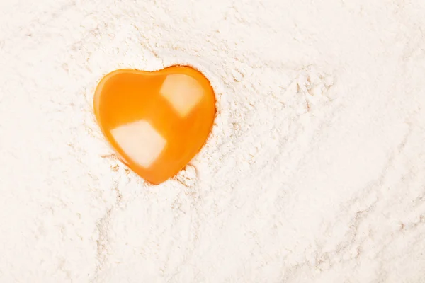 Tuorlo d'uovo a forma di cuore sulla farina — Foto Stock