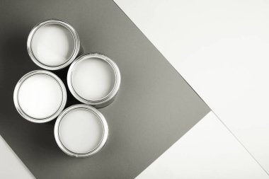 Gri ve beyaz geometrik arka planda beyaz boya dolu boya kutuları, ev gelişimini ve yaratıcı projeleri temsil ediyor. 2026 'nın beyaz bulutlu dansçısı.