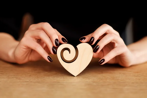 Handen met houten hart — Stockfoto