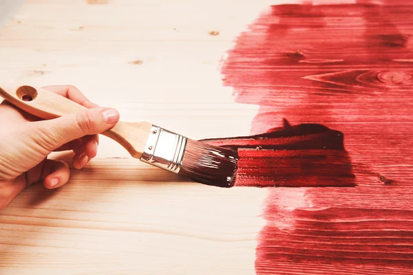 Hand schilderij rode kleur op houten tafel — Stockfoto