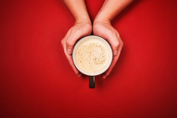 Due mani che tengono una tazza di caffè fresco — Foto Stock