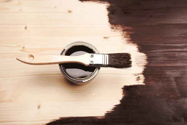 Målarfärg kan med pensel på trä bakgrund — Stockfoto