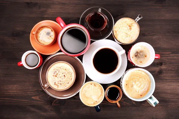 Veel kopjes koffie op houten tafel — Stockfoto