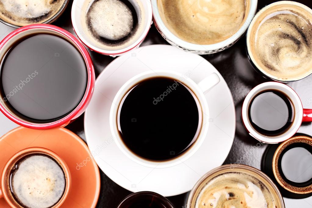 Many cups of coffee on wooden table