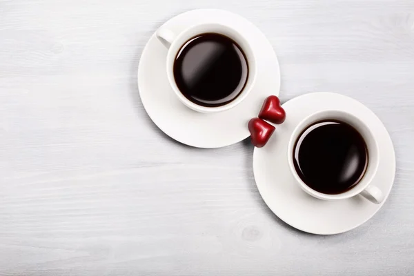 Two cups of coffee and heart shaped sweets — Stock Photo, Image