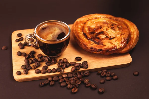 Tasse Kaffee mit leckerem Brötchen — Stockfoto