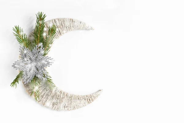 Karlı köknar ağacı dalı ve gümüş çiçek ya da beyaz hilal üzerinde yıldız. Kopyalama alanı olan üst görünüm. Düz yatıyordu. Noel arkaplanı ya da kartpostal. Yeni yıl kavramı.