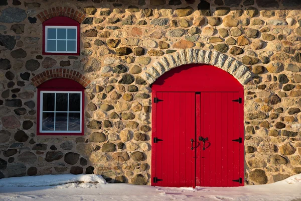 Starej stodole kamienia z jasny czerwony drzwi — Zdjęcie stockowe