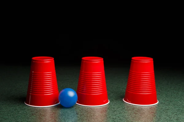 Drie rode Cups en een blauwe bal met het — Stockfoto