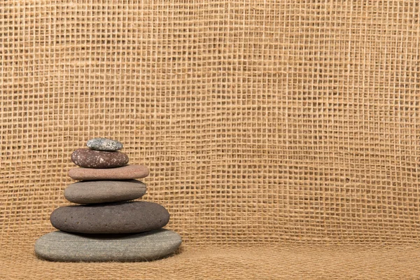 Piedra Cairn sobre fondo de arpillera —  Fotos de Stock