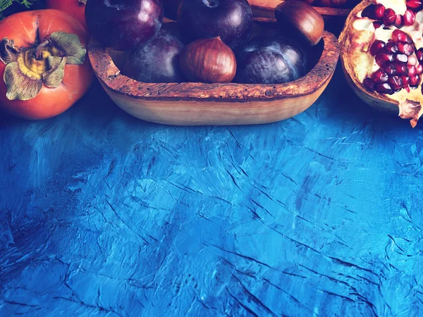Winter fruit on blue textured background — Stock Photo, Image
